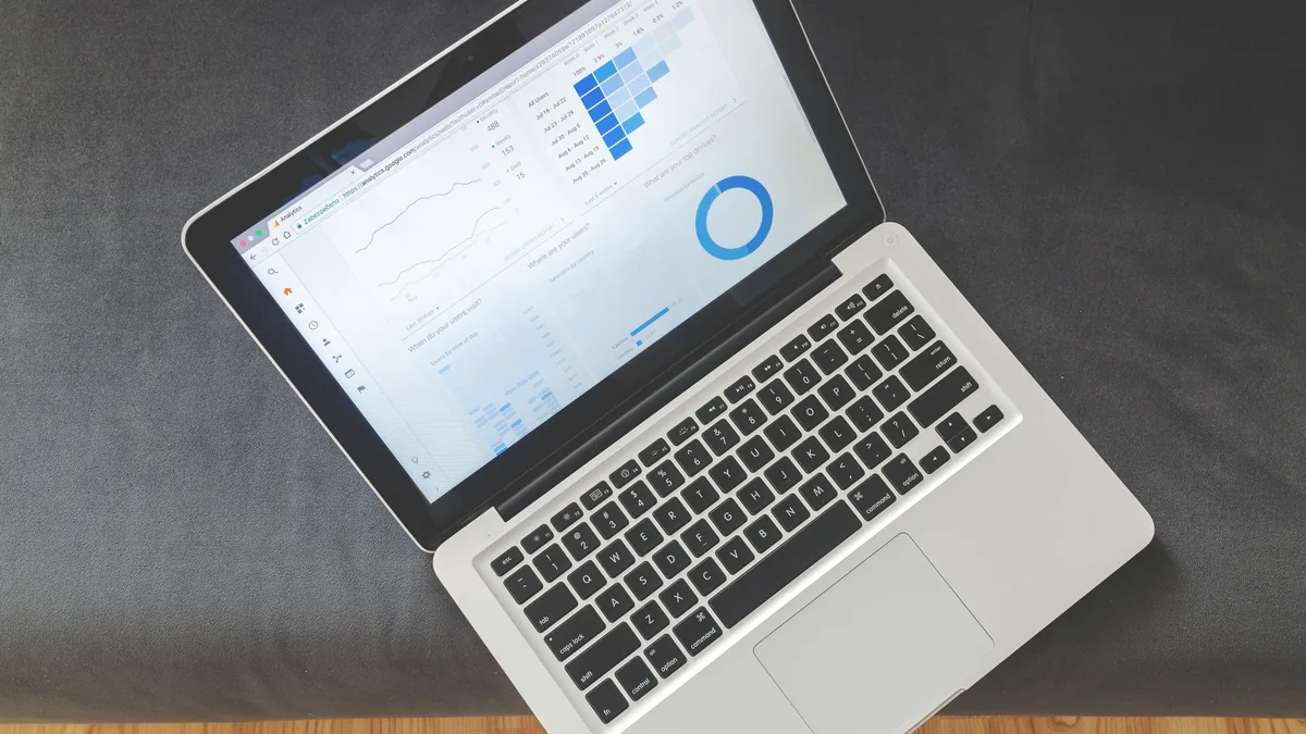 Laptop and charts on a desk — the monthly review where hosts track Airbnb occupancy data