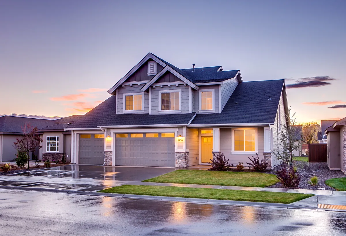AvantStay comparison for owners, Craftsman house with lit windows at dusk after rain