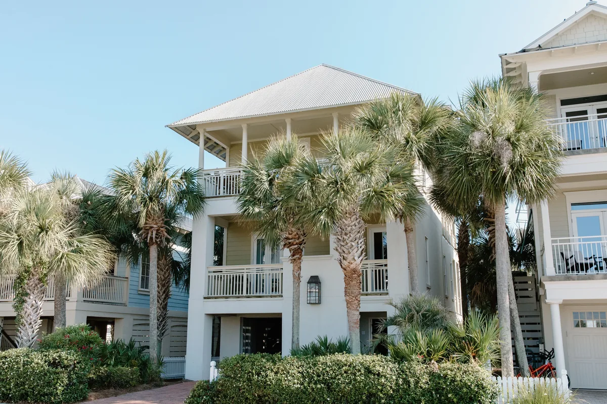 Awning review, White multi-storey coastal house with palms and outside stairs