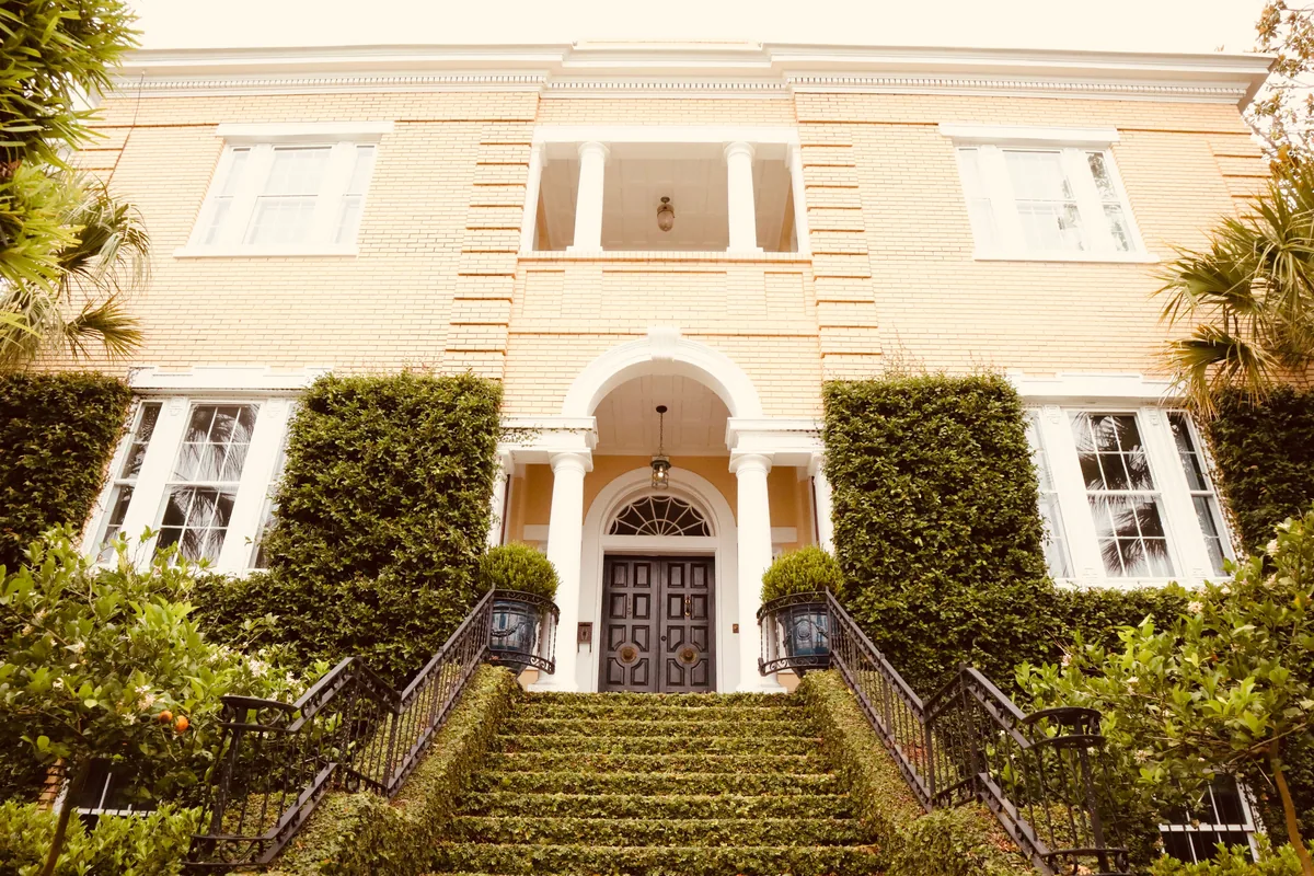 Portoro alternatives for Airbnb owners, Grand cream Southern mansion with an arched entrance and ivy-covered walls