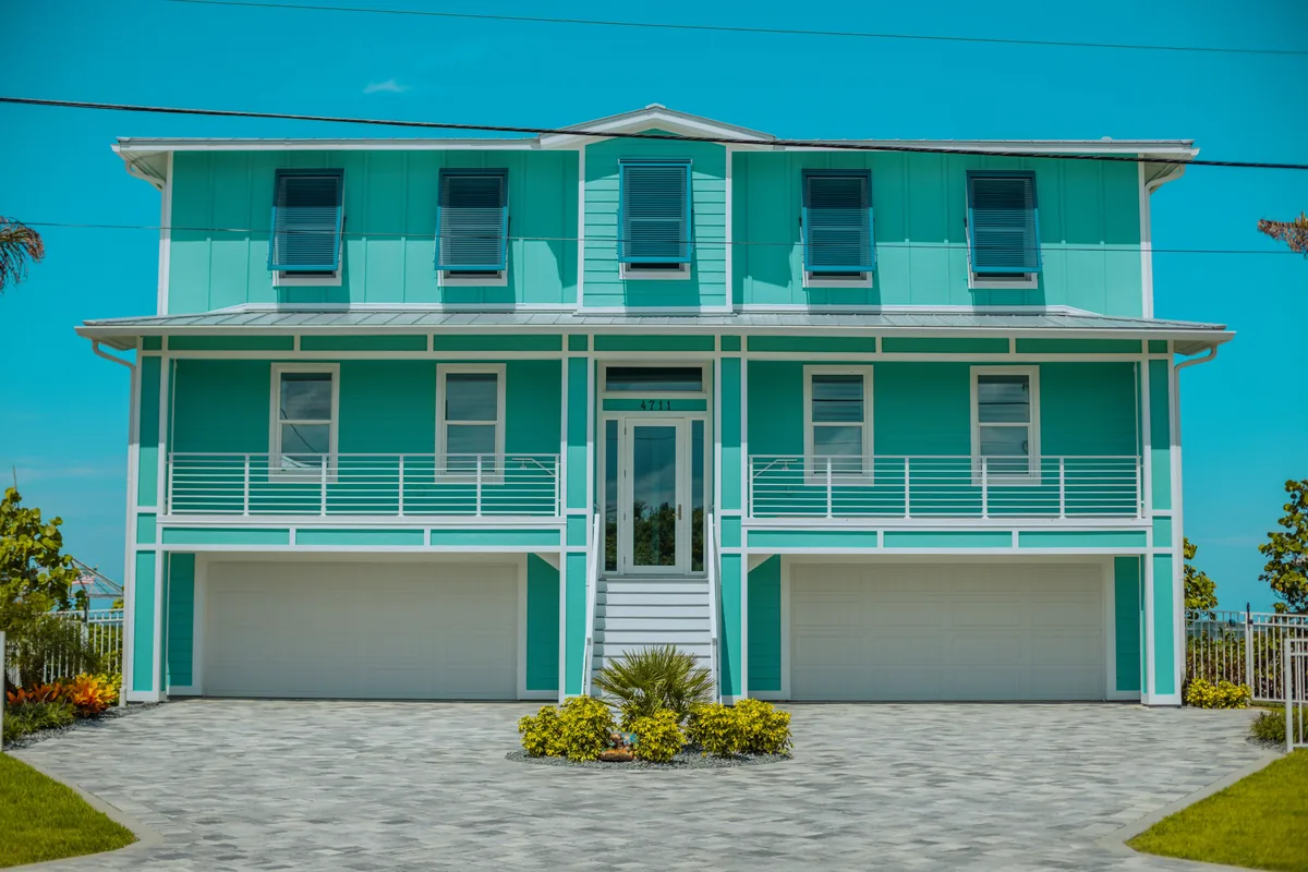 360 Blue alternatives for Airbnb owners, Turquoise two-storey beach house with covered porches and a double garage