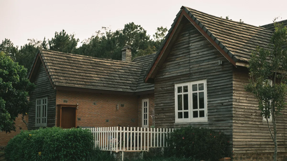 Outer Banks Blue alternatives for Airbnb owners, Weathered timber cottage with a picket fence set back among coastal trees