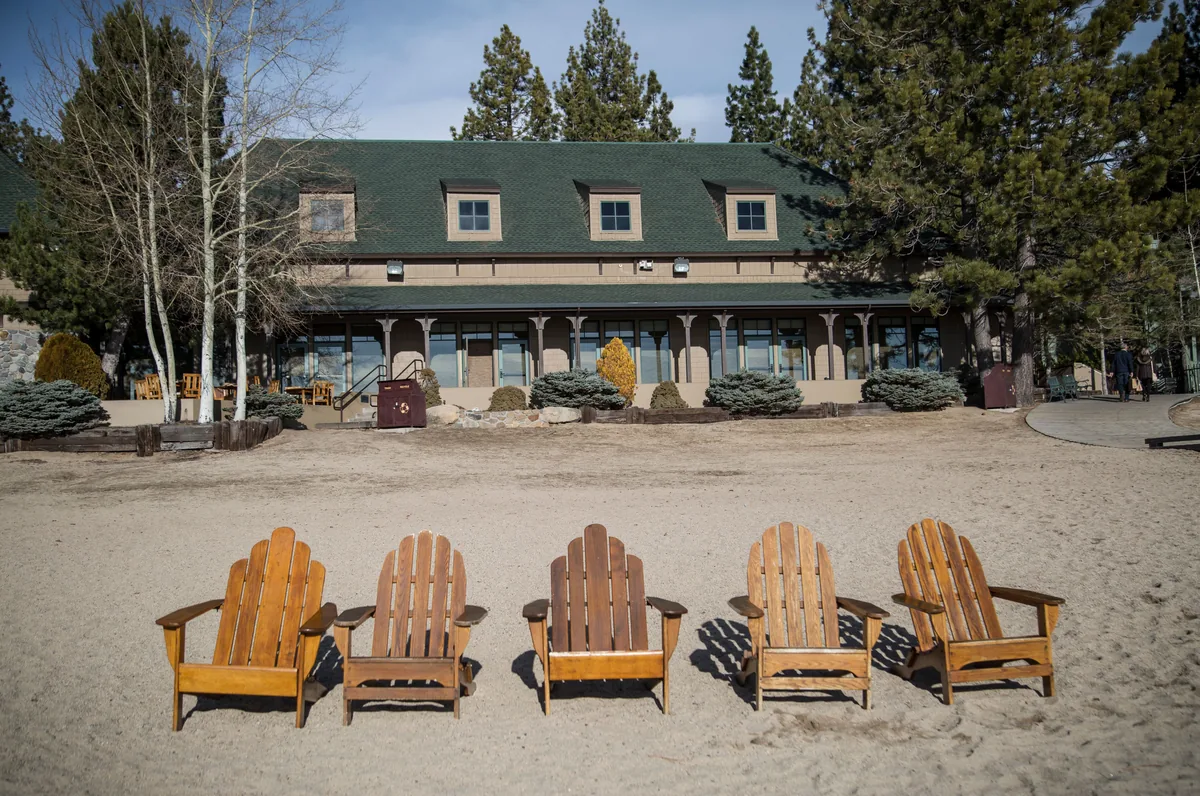 Tahoe Signature Properties management fees, Rustic lakeside lodge with Adirondack chairs lined up on the sand
