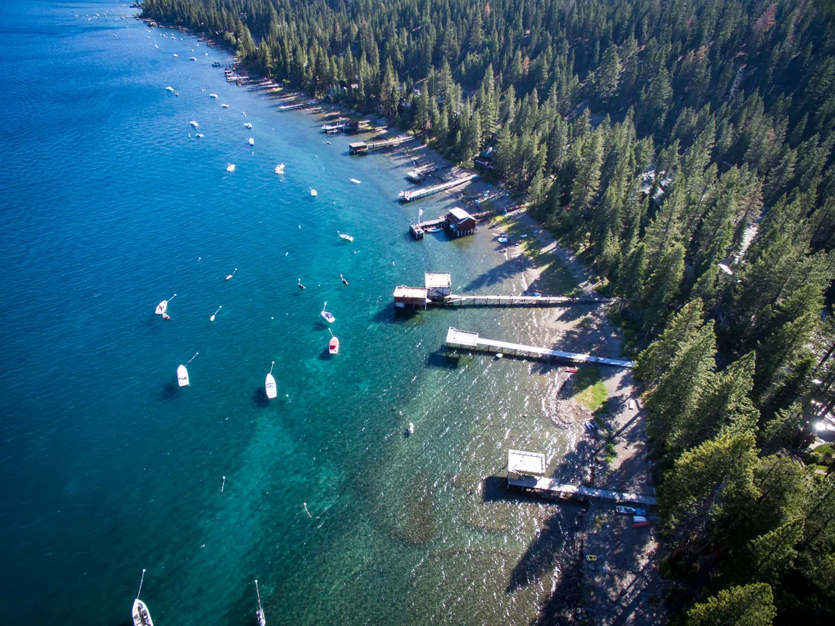 Tahoe Signature Properties alternatives for Airbnb owners, Aerial view of a forested Lake Tahoe shoreline with boat docks