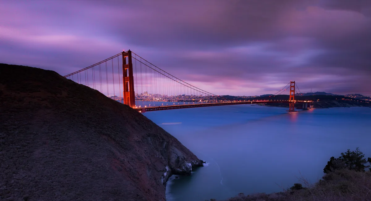 Guesthop alternatives for Airbnb owners, Golden Gate Bridge lit at dusk under a violet sky