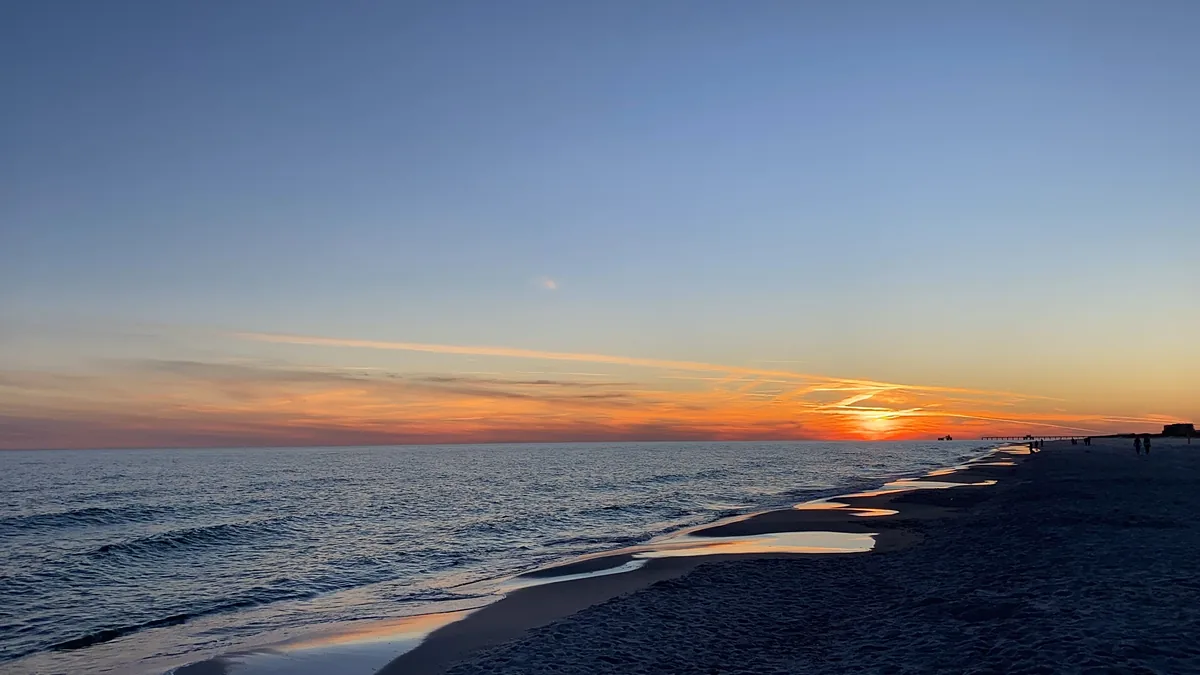 Prickett Properties alternatives for Airbnb owners, Sun setting over the Gulf of Mexico beyond a distant pier