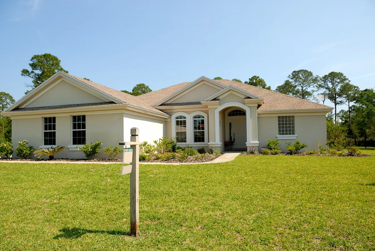 iTrip management fees, Single-storey stucco house with a lawn and a signpost at the kerb