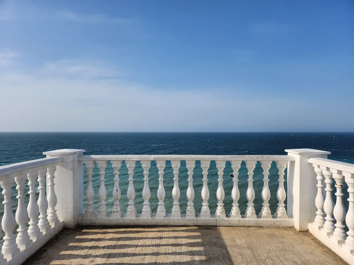 Vacasa alternatives for vacation rental owners, White stone balustrade on a balcony above the sea
