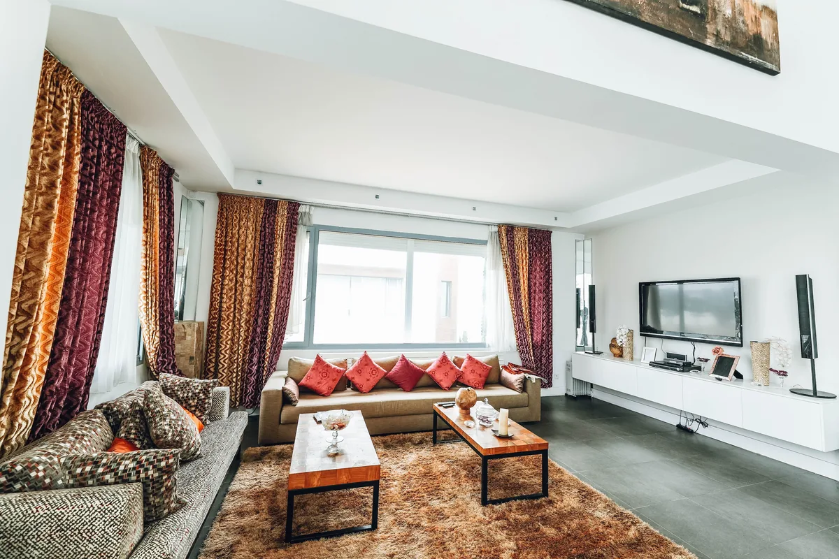 VTrips management fees, Living room with red patterned sofas and long curtains