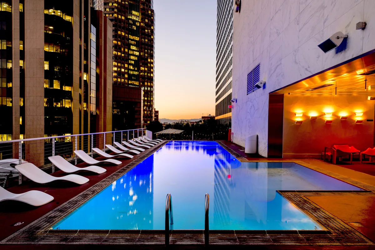 VTrips alternatives for Airbnb owners, Rooftop pool lit at night above city lights