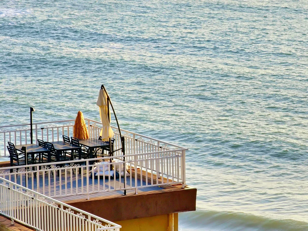 Grand Welcome alternatives for Airbnb owners, Terrace tables and folded umbrellas set out above the water