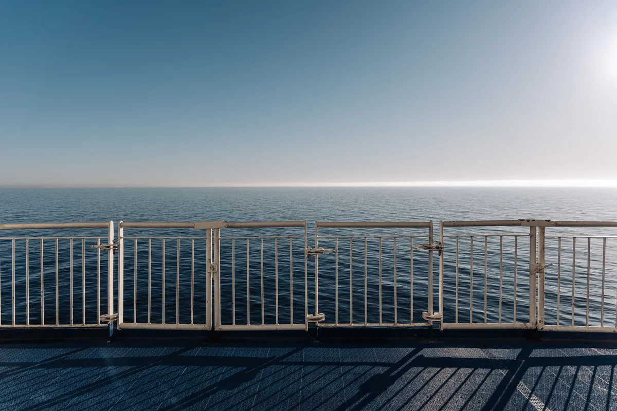 Grand Welcome management fees, Open deck with a railing above a calm sea