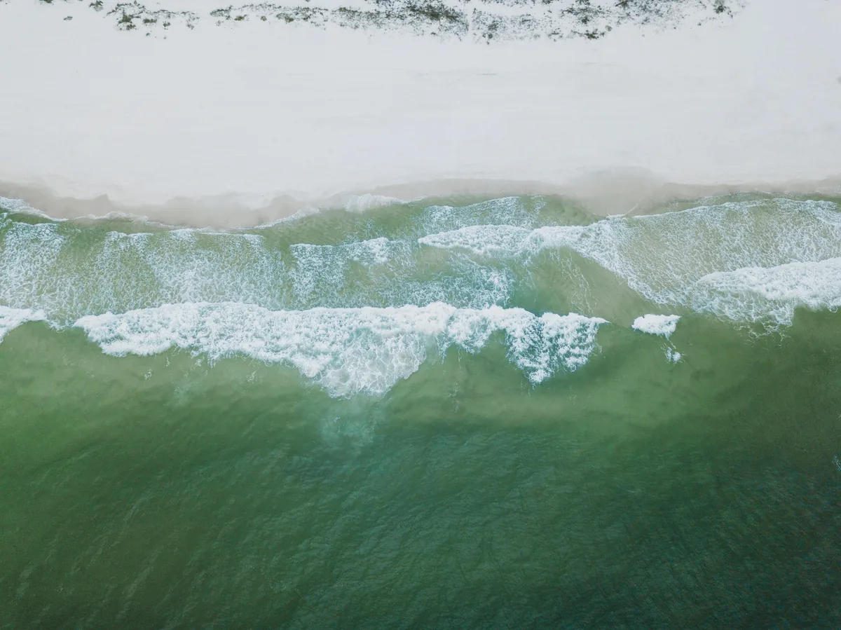 Harris Vacations alternatives for Airbnb owners, Waves breaking onto bright white sand seen from directly above