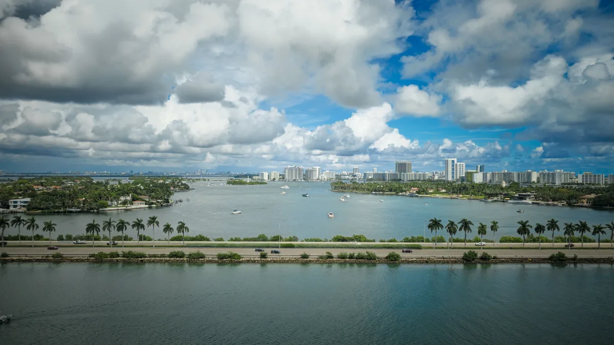 Host & Keep management fees, Causeway and palms crossing the bay under piled cloud