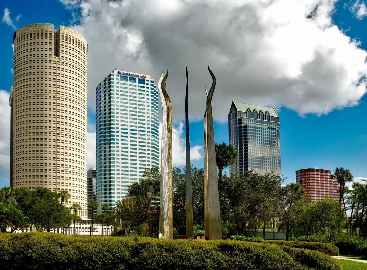 Tampa Bay Stays alternatives for Airbnb owners, Curved Tampa office towers behind a sculpture in a riverside park