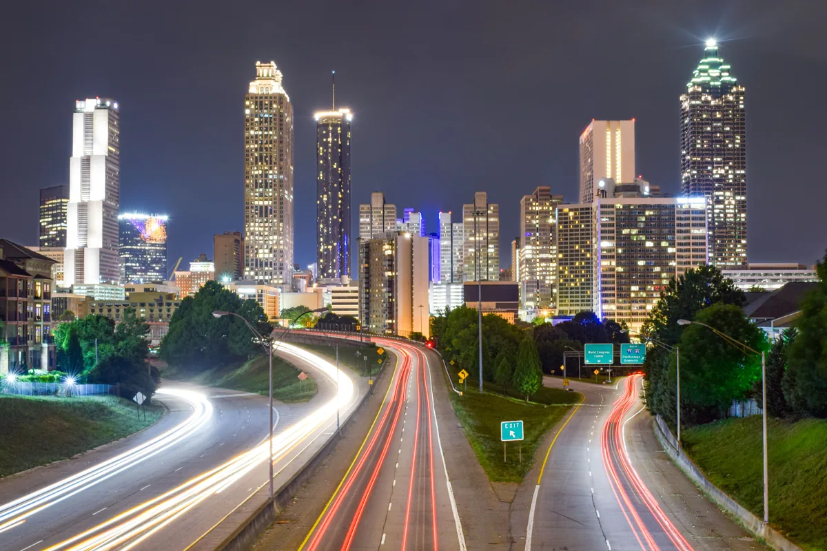 Hitlist Rental Management alternatives for Airbnb owners, Light trails on the highway below the Atlanta skyline at night
