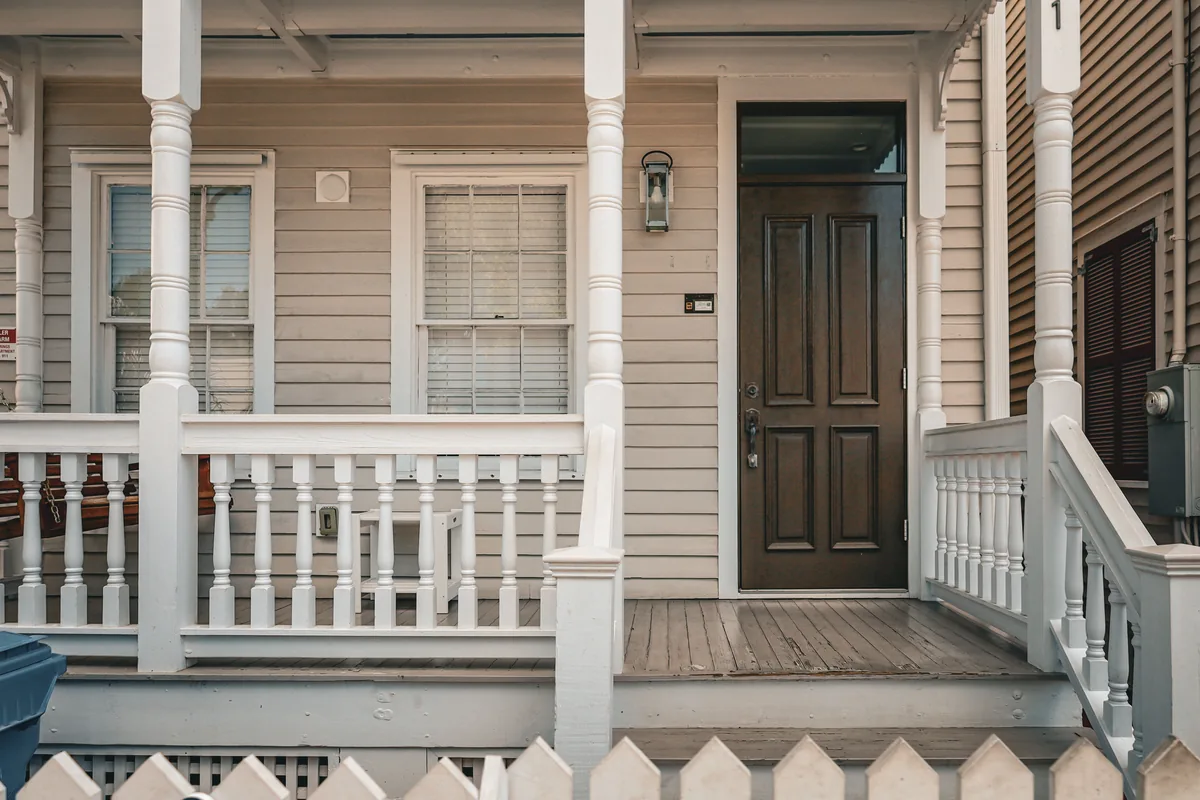 Misfit Homes management fees, Timber porch with a painted railing and a panelled front door