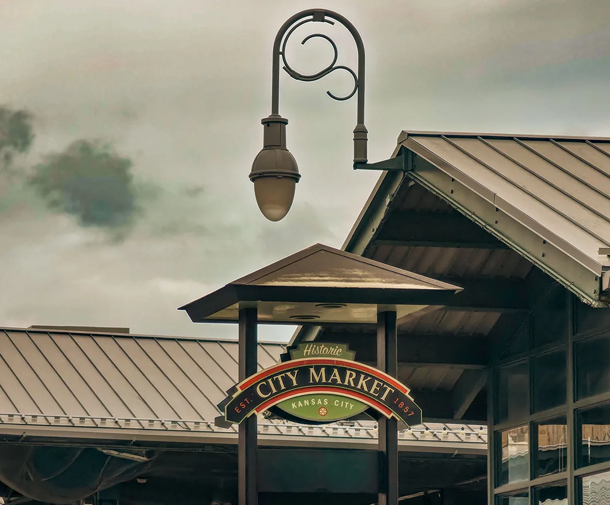 Next Guest KC alternatives for Airbnb owners, City Market sign hanging beneath a street lamp and canopy roofs