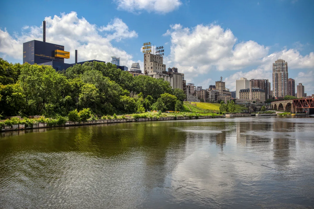 The Works BnB alternatives for Airbnb owners, Wooded riverbank with the Minneapolis skyline in the distance