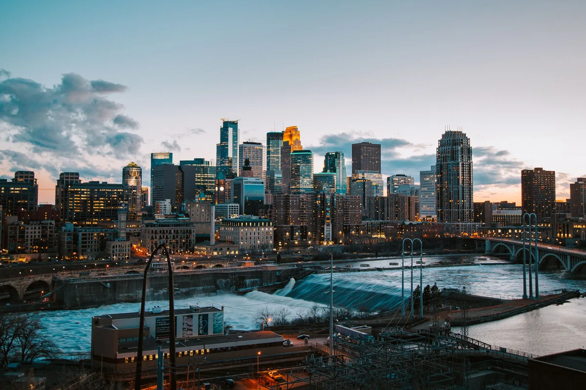 The Works BnB management fees, Minneapolis towers at dusk above the river and its bridges