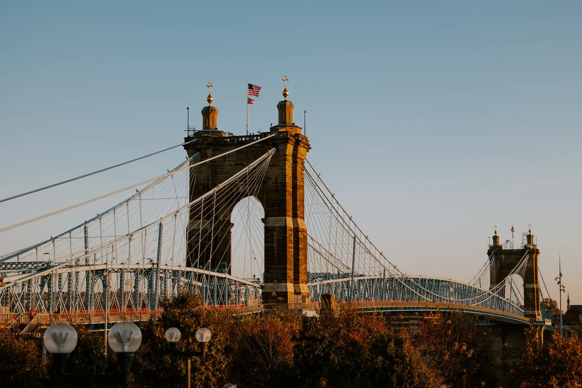 Stay Cincinnati alternatives for Airbnb owners, Stone bridge towers and cables lit by low afternoon sun