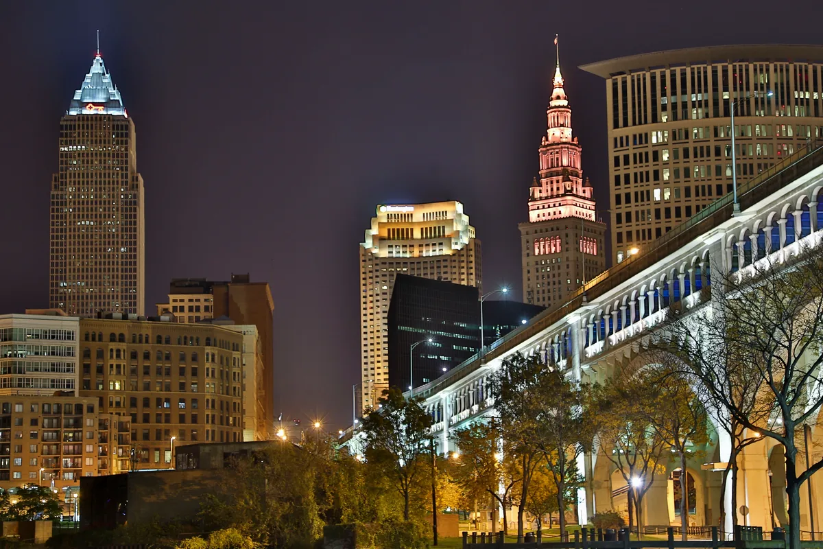 HostPros management fees, Cleveland skyline lit at night beside an illuminated bridge