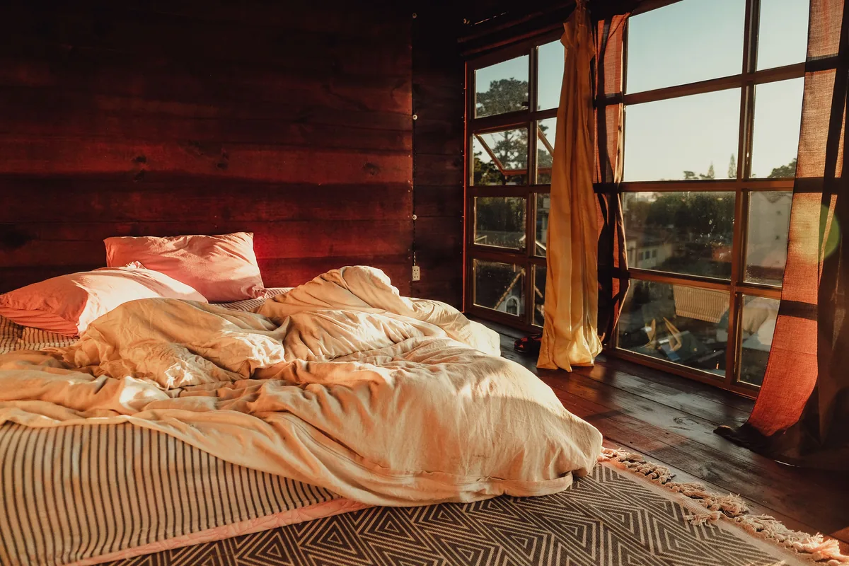 Cabin bedroom, red timber, big windows — Vrbo Host Fees: Comprehensive Guide to Maximize Your Rental Income
