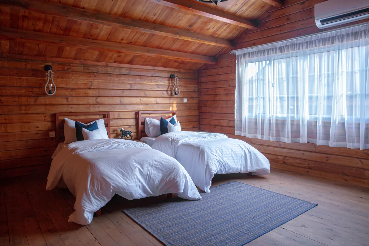 Twin beds in a log cabin bedroom — Airbnb Cleaning Checklist: The Complete Room-by-Room Turnover Guide