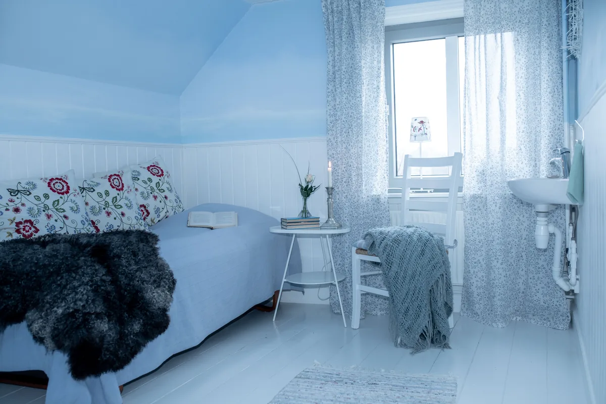 Attic bedroom, white boards, floral bedding — Airbnb Channel Manager: How to Sync Your Listings Across Platforms