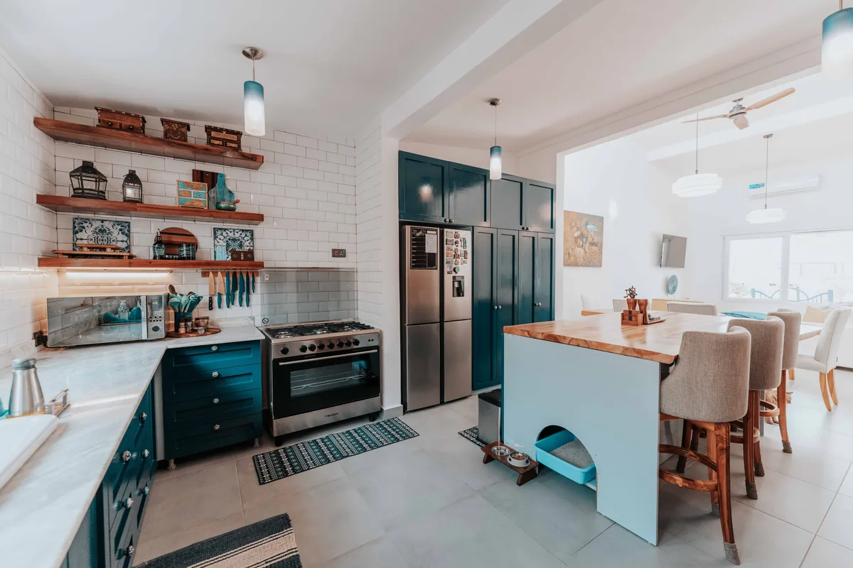 Open plan kitchen with a teal range — Airbnb Guest Screening: How to Vet Guests and Protect Your Property
