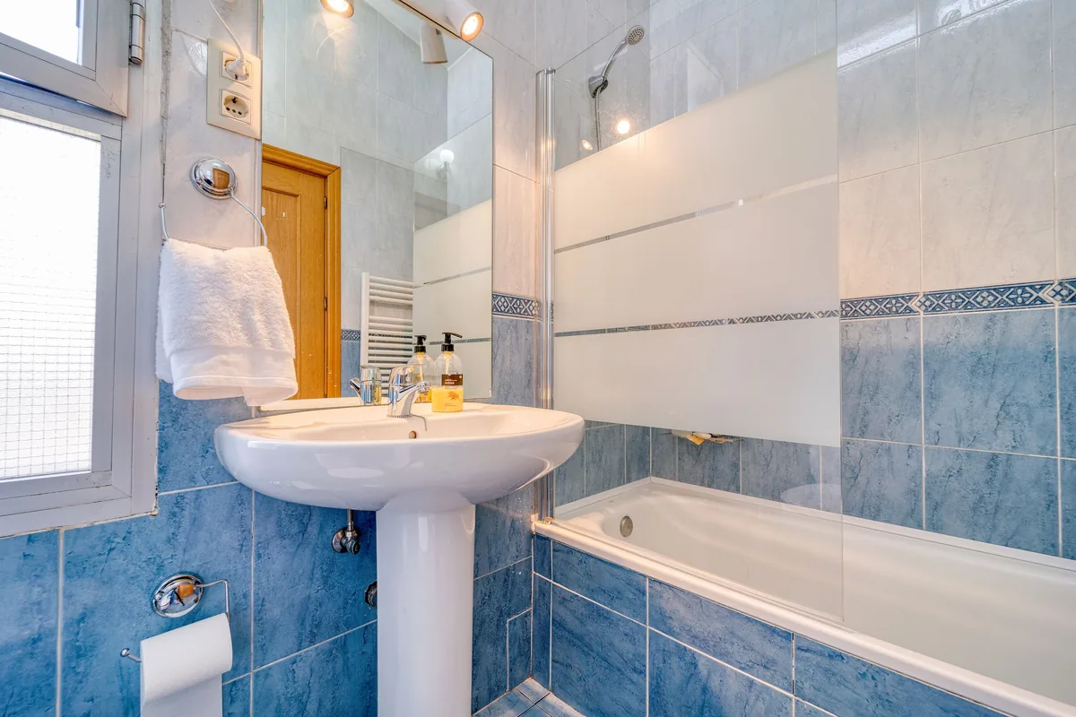 Blue tiled bathroom with a tub — Airbnb Travel Insurance: Is It Worth It for Guests and Hosts?