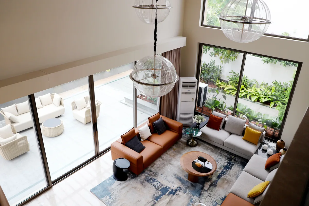 Double-height living room with planting — Airbnb Management Fee: What Property Managers Charge in 2026