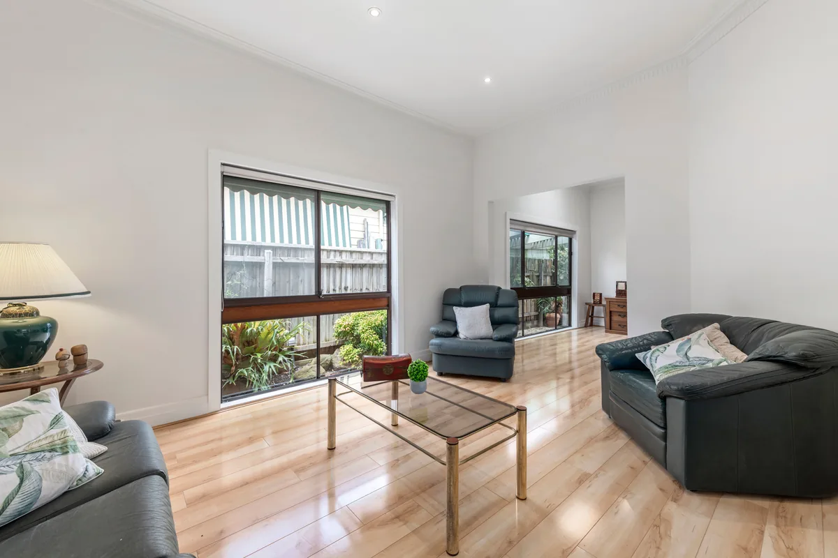 Bright living room, dark sofas — Airbnb Management Fee: What Property Managers Charge in 2026