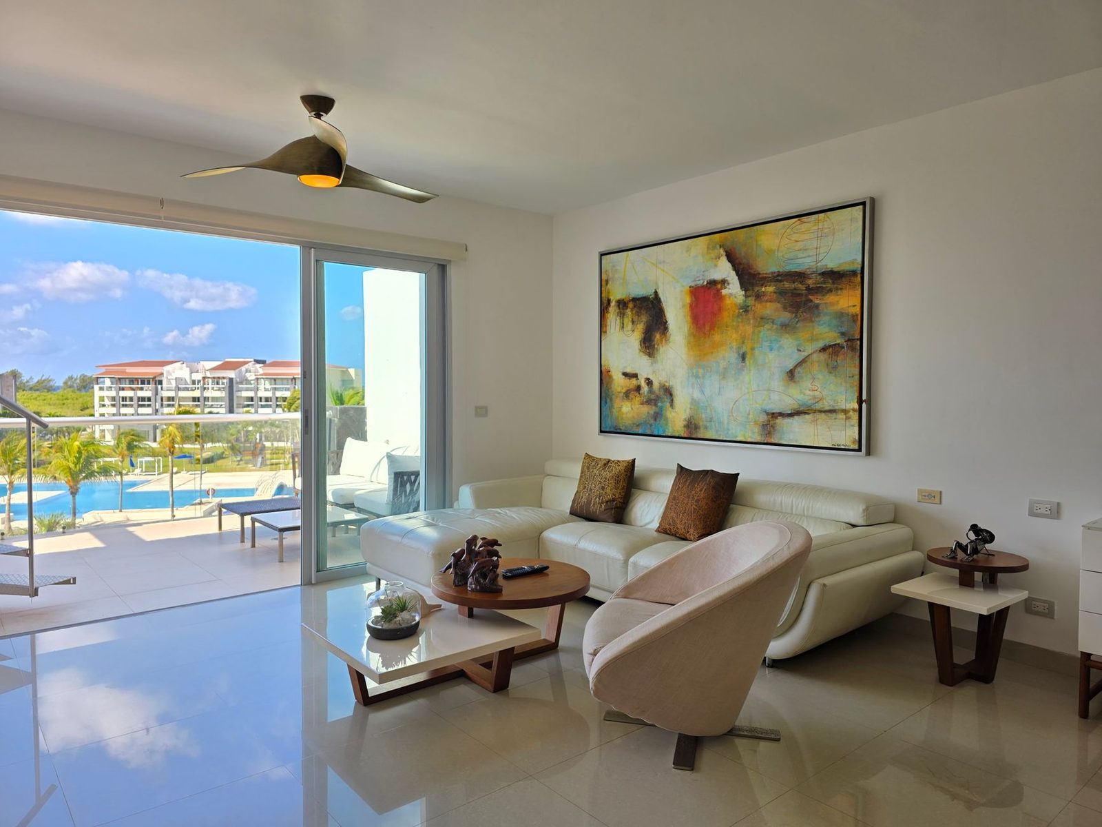 A beach-condominium living room opening onto a pool terrace