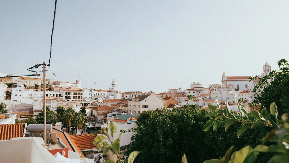 Gestao de Alojamento Local management fees, White rooftops of an Algarve town above the greenery