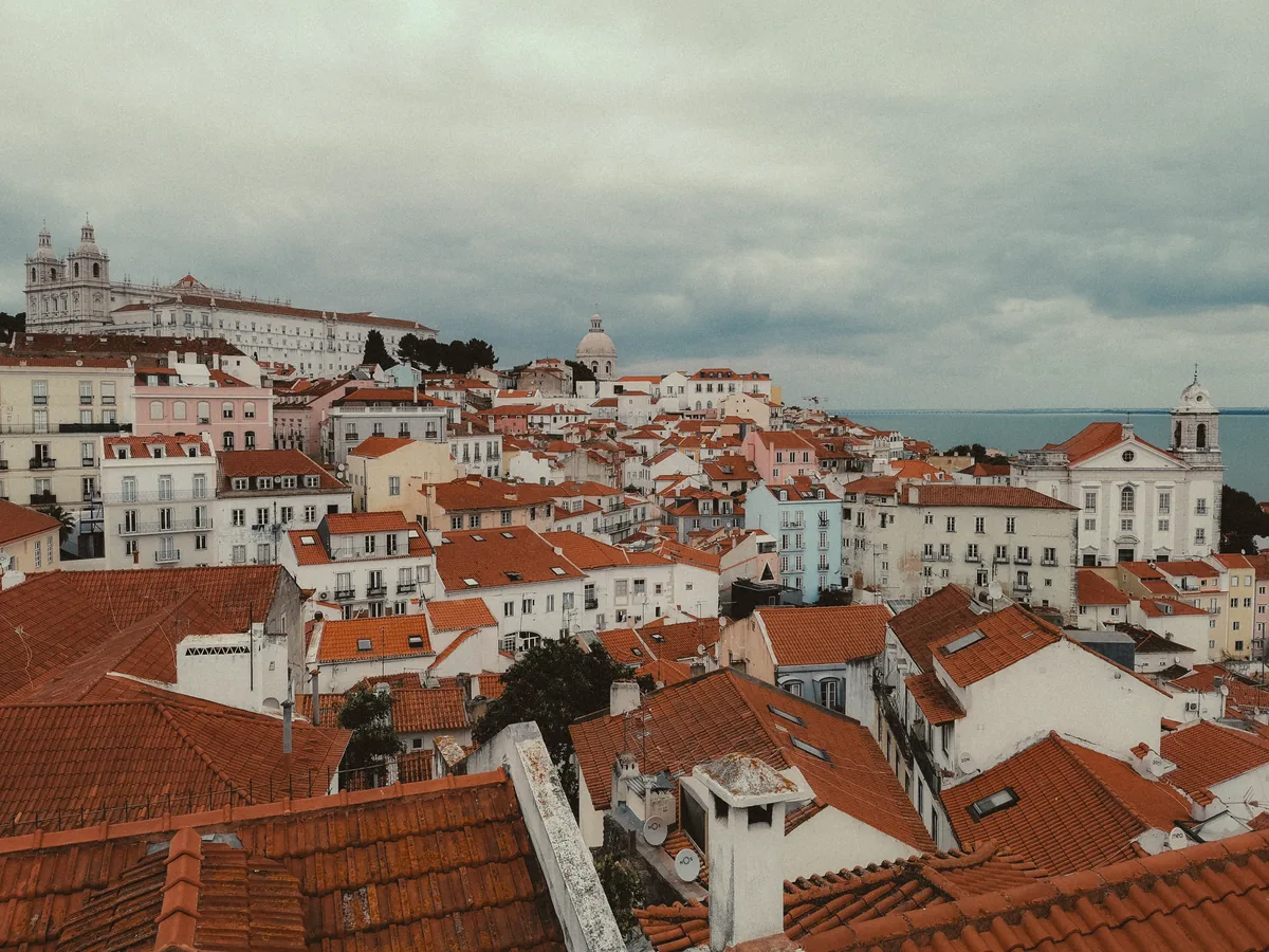 Whome management fees, Terracotta rooftops of central Lisbon under cloud