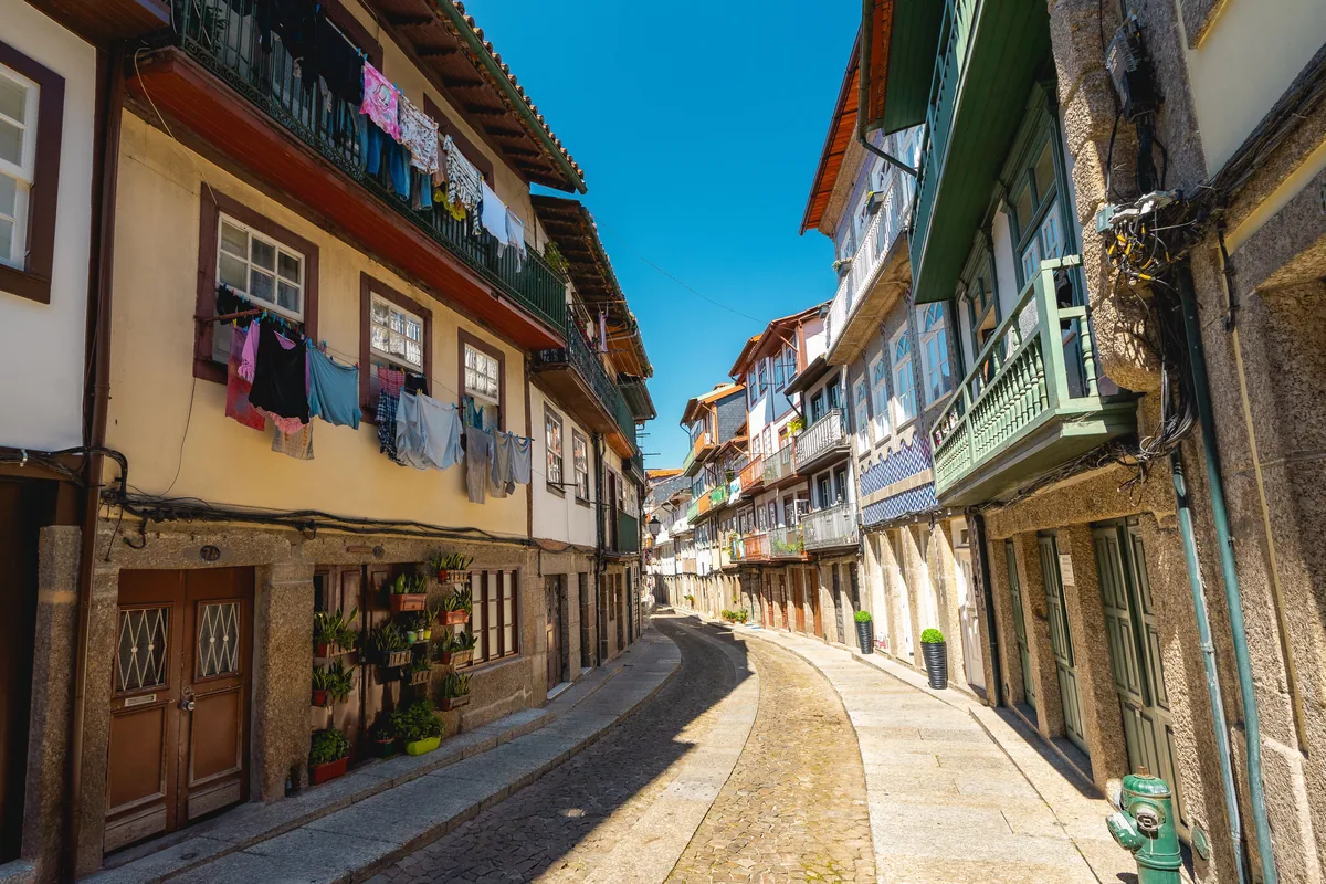 YourHost alternatives for Portuguese owners, Cobbled street of balconied houses in a northern old town