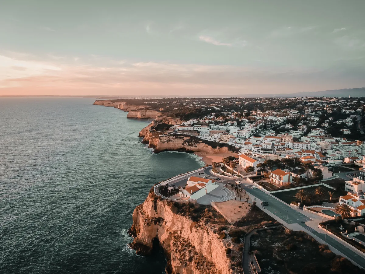 Bed and Sun management fees, Coastal town on red cliffs at dusk in the Algarve