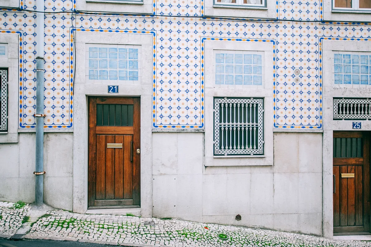 Houst management fees, Blue azulejo facade and wooden door on a Lisbon house