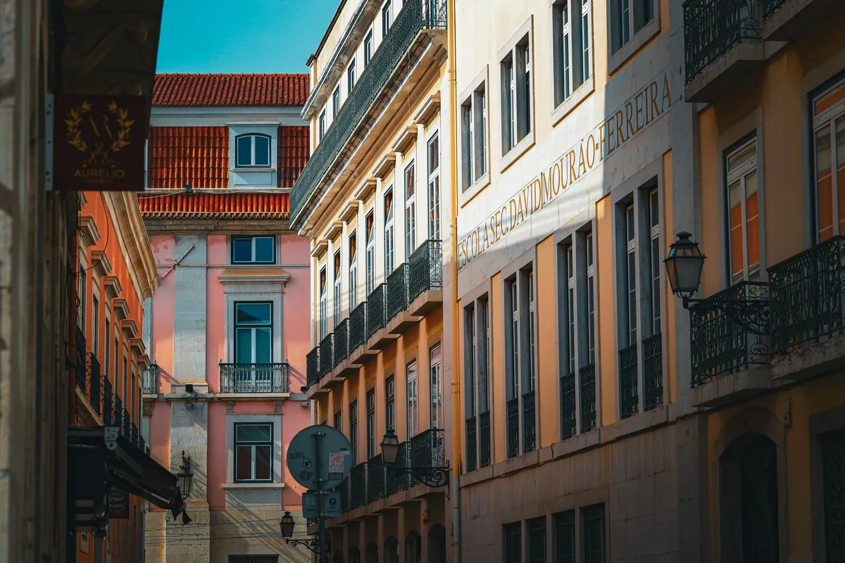 Houst alternatives Portugal, Row of painted Lisbon facades with wrought-iron balconies