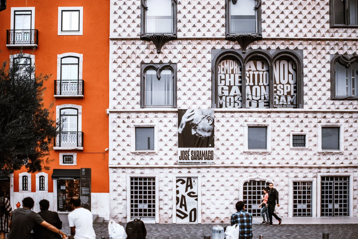 UpperKey management fees, Tiled white facade beside an orange building in Lisbon