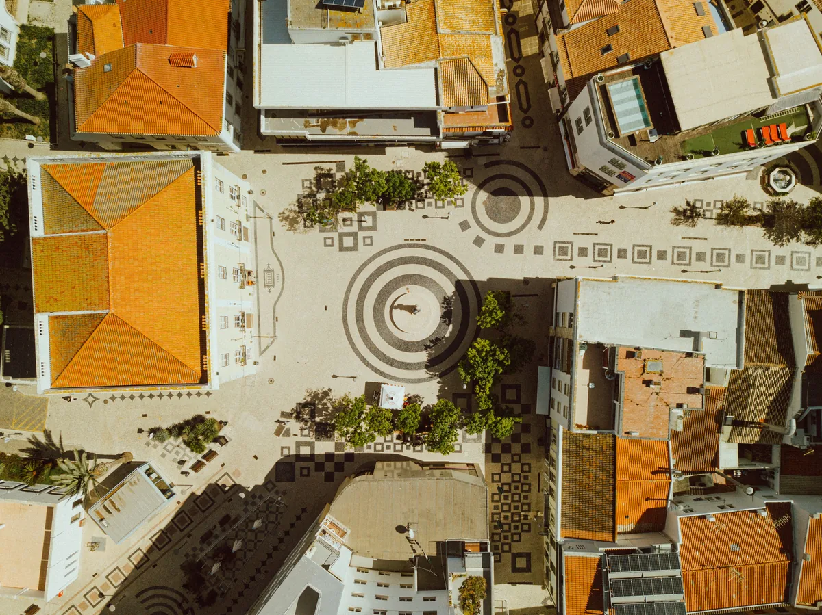 Coral Algarve management fees, Orange rooftops and patterned paving seen from above