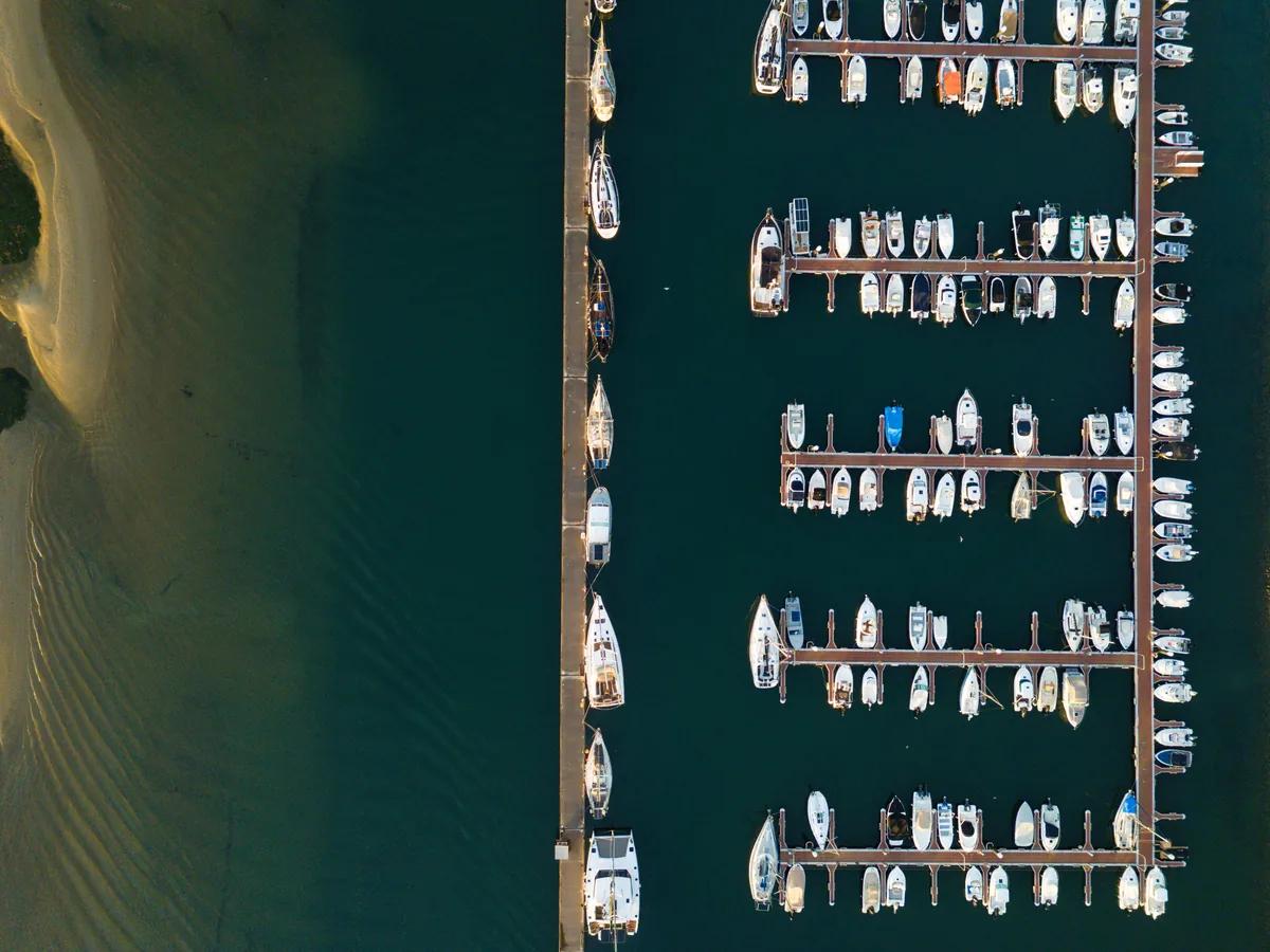 Enjoy Your Stay management fees, Aerial view of a marina and sandbank on the Algarve coast