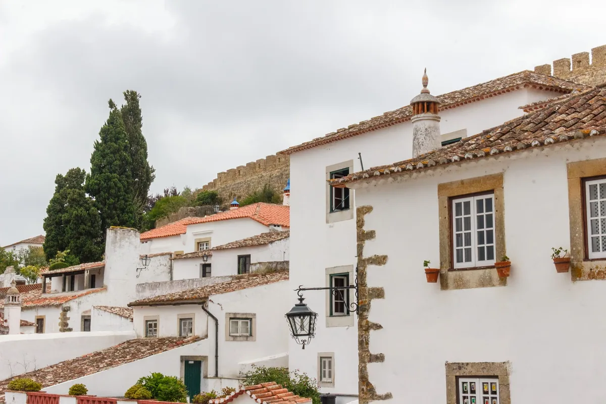 GestHomes alternatives Portugal, White houses with terracotta roofs in a walled Oeste town