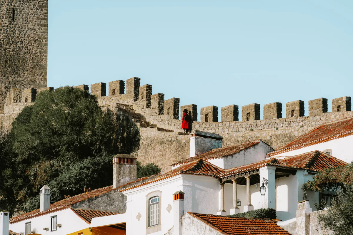 AB-House Property Management management fees, Castle battlements above white houses in the Oeste