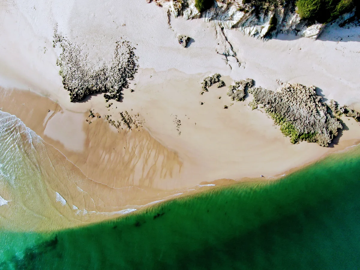 Gest4Hotel management fees, Aerial view of a beach and green water on the Alentejo coast