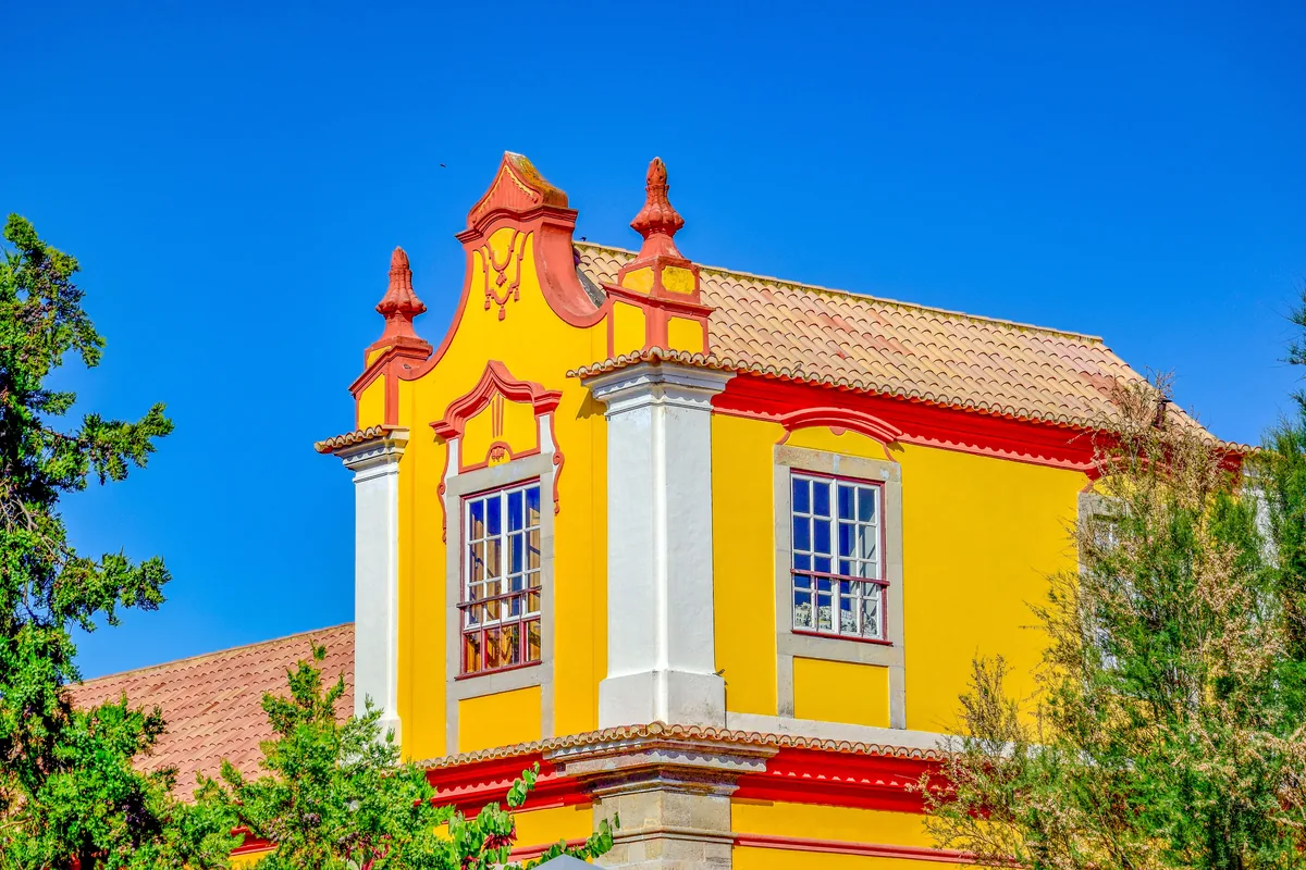 My Choice management fees, Yellow and red baroque facade in Tavira