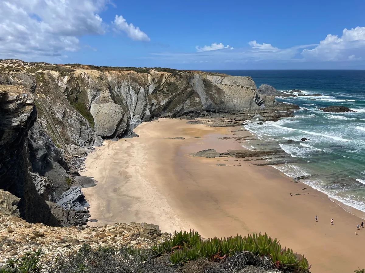 A wide sand beach between cliffs on the Alentejo coast