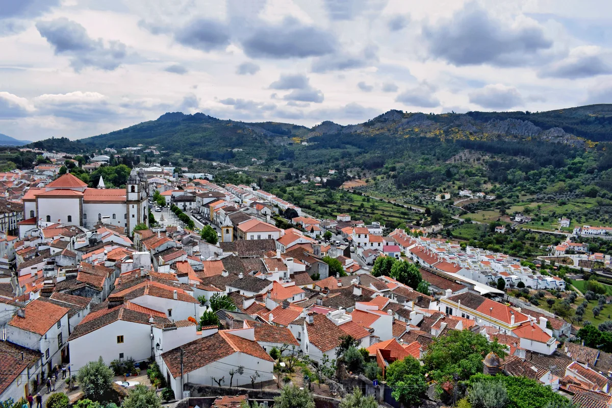 White houses and red roofs of a hill town below the Alentejo sierra