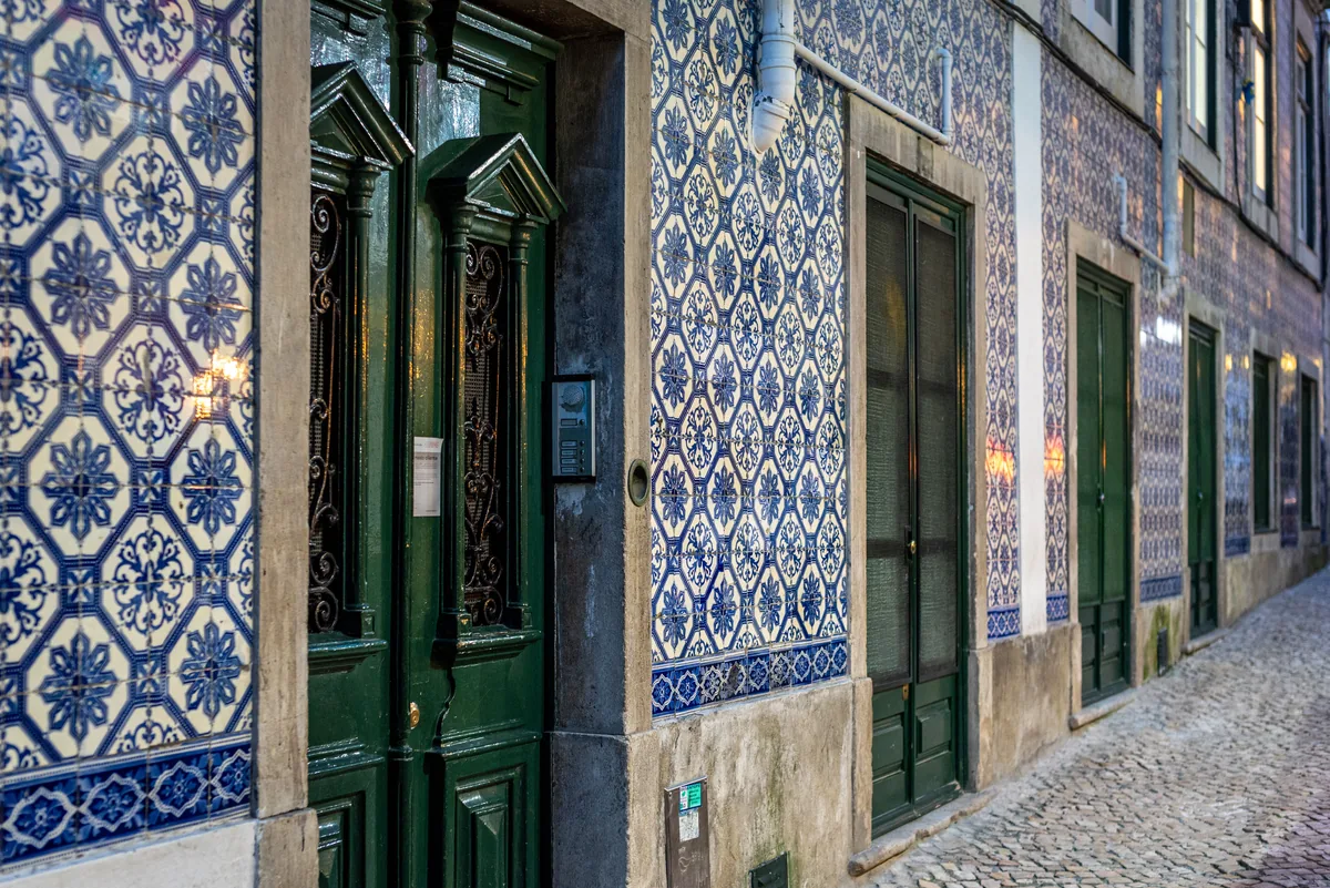 Blue and white tiled walls and a green doorway on a Portuguese street